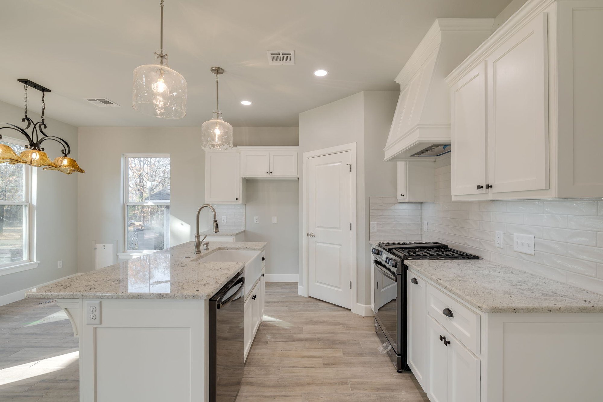 Modern open-concept design with pendant lighting and stainless steel appliances.