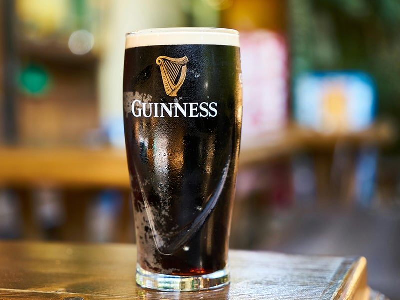 Cold dark stout served in a branded Guinness glass.